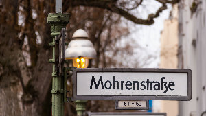 Sie sehen ein Straßenschild mit der Aufschrift „Mohrenstraße“