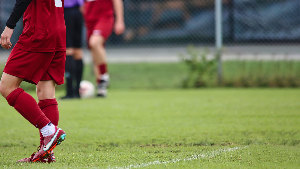 Sie sehen einen Fußballspieler auf dem Rasen.