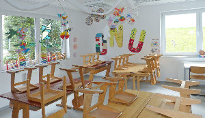 Sie sehen ein leeres Klassenzimmer einer Grundschule mit Stühlen und Tischen.