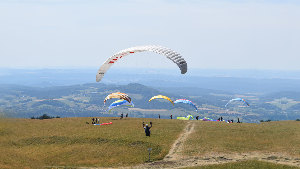 Sie sehen einen Gleitschirmflieger beim Starten.