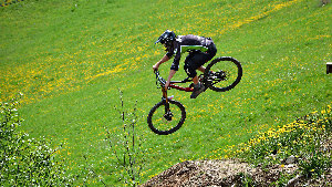 Sie sehen einen Mountain-Bike-Fahrer bei einem Sprung mit seinem Bike.