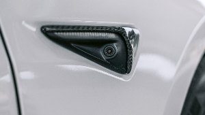 Sie sehen die kaum sichtbare Seitenkamera eines modernen Elektroautos zur Umgebungsüberwachung.