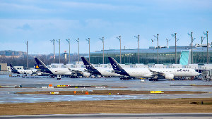 Sie sehen mehrere Flugzeuge der Lufthansa auf am Terminal eines Flughafens.