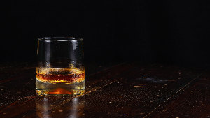 Sie sehen ein Whiskeyglas mit brauner Flüssigkeit.