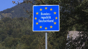 Sie sehen ein Verkehrszeichen, welches den Beginn des Staatsgebietes der Bundesrepublik Deutschland ankündigt.
