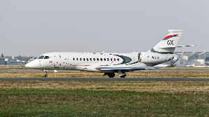 Sie sehen ein Geschäftsflugzeug vom Typ Falcon 6x des Hersteller Dassault Aviation auf der Rollbahn eines Flughafens.