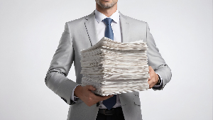 Sie sehen einen Mann mit einem großen Stapel Papier in der Hand.
