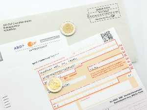 Sie sehen einen SEPA-Überweisungsschein zur Zahlung des Rundfunkbeitrages, der auf einem Schreiben vom Beitragsservice der öffentlich-rechtlichen Sendeanstalten (ARD, ZDF und Deutschlandradio) liegt.