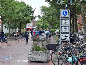 Sie sehen den Eingang einer Fußgängerzone, mit der passenden Beschilderung, sowie einem tageszeitabhängigem Fahrverbot für Fahrräder.